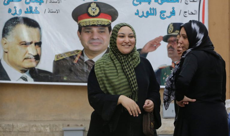 Egyptian women chat in front of a banner showing presidential candidate Abdel-Fattah el-Sissi, the country's former military chief, center, along with late presidents Anwar Sadat, right, and Gamal Abdel-Nasser, left, two days before presidential elections in Cairo, Egypt, Saturday, May 24, 2014. Considered all but certain to win is el-Sissi, the man who removed the former president, Mohammed Morsi. El-Sissi, who for the past 10 months has been the most powerful figure in Egypt, faces one other candidate in the race, leftist politician Hamdeen Sabahi, who finished third in the 2012 presidential election. (AP Photo/Amr Nabil)