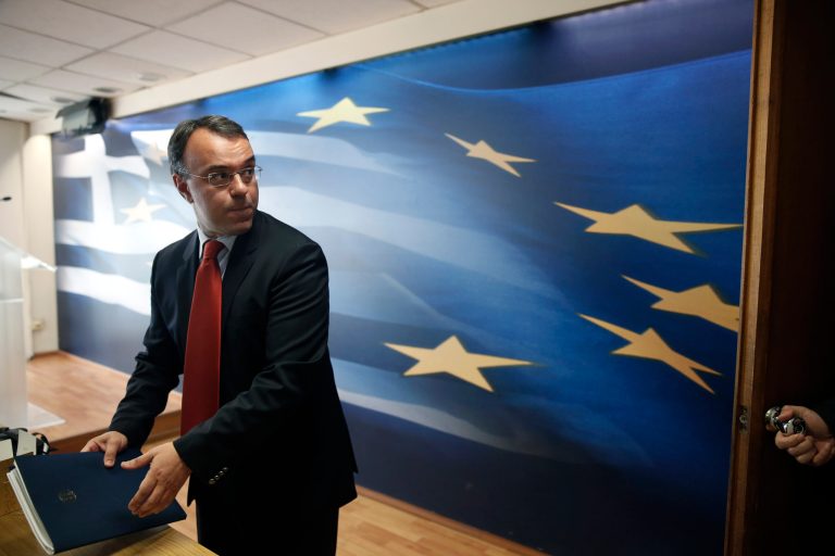 Greek Deputy Finance Minister Christos Staikouras leaves a press conference in Athens, on Wednesday, April 23, 2014. Greece has reached a major financial milestone that its creditors demanded as a precondition for being granted more debt relief, the European Commission said Wednesday. Staikouras said the country recorded a surplus of 1.5 billion euros last year, without the cost of debt servicing and a bank support package. (AP Photo/Petros Giannakouris)