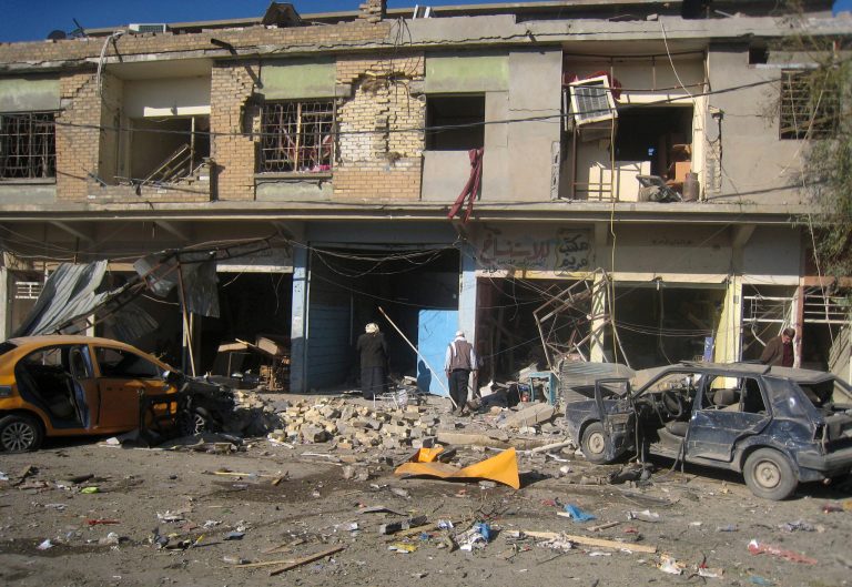 Civilians inspect the site of a car bomb attack in Kirkuk, 180 miles north of Baghdad, Iraq, on Tuesday. (AP/Emad Matti)