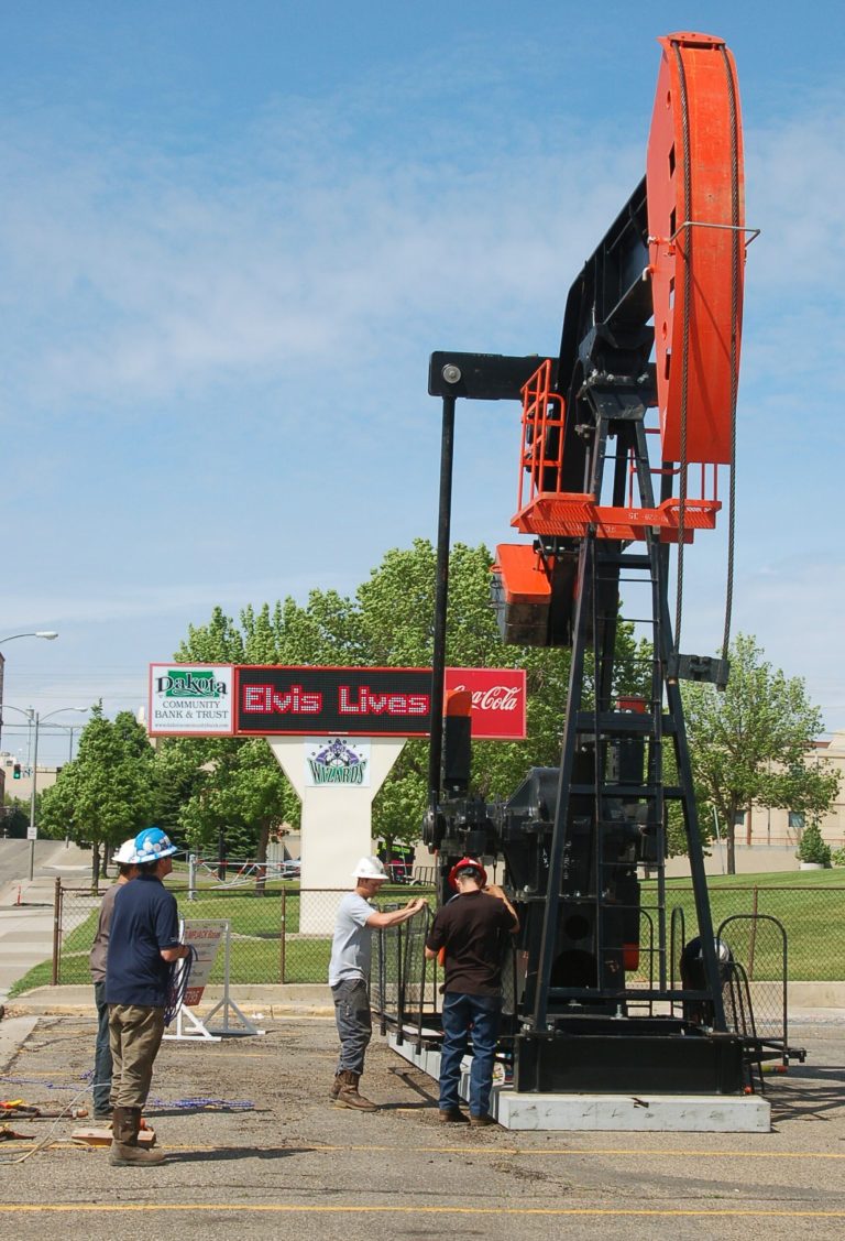 FILE - In this May 22, 2012, file photo, workers erect an oil pump at the Williston Basin Petroleum Conference and Expo in Bismarck, N.D. The three-day Williston Basin Petroleum Conference and Expo starts Tuesday, May 20, 2014, at the Bismarck Civic Center, which is undergoing a $27 million expansion, in part because of the soaring interest in the oil conference. (AP Photo/James MacPherson)