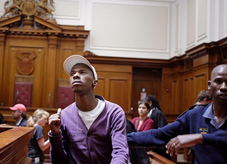   Xolile Mngeni, left, shows his family members a thumbs up after being sentenced in court at Cape Town, South Africa, Wednesday, Dec. 5, 2012. A South African judge sentenced the triggerman in the 2010 honeymoon slaying of a Swedish bride to life in prison Wednesday, calling the shooter 