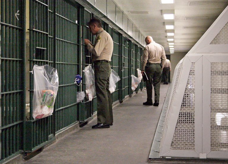 In this Oct. 3, 2012, file photo, Los Angeles County Sheriff's deputies inspect a cell block at the Men's Central Jail in downtown Los Angeles. (AP Photo/Reed Saxon)