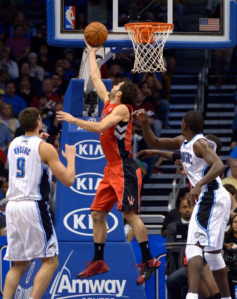   Toronto Raptors guard Jose Calderon, center, of Spain, puts up a shot between Orlando Magic center Nikola Vucevic (9), of Montenegro, and forward Andrew Nicholson, right, during the first half of an NBA basketball game in Orlando, Fla., Saturday, Dec. 29, 2012. (AP Photo/Phelan M. Ebenhack)  