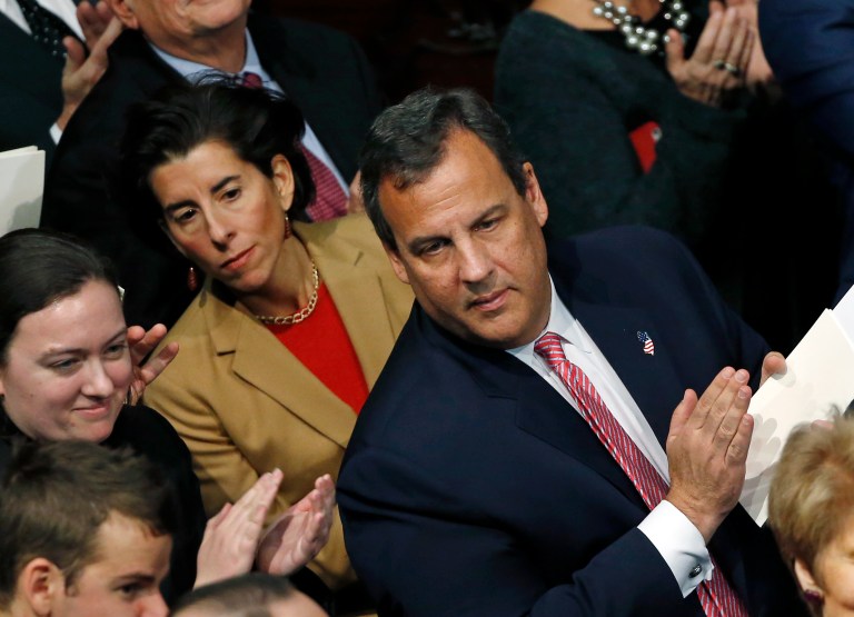 New Jersey Gov. Chris Christie, right, and Rhode Island Gov. Gina Raimondo, left in red, lean out to see the procession in the House Chambers at the Statehouse in Boston, Thursday, Jan. 8, 2015 during the inauguration of Charlie Baker as governor of Massachusetts. (AP Photo/Elise Amendola)