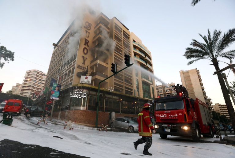 Fire engines work on extinguishing a fire after a suicide bomber blew himself up in his room at a Beirut hotel, Lebanon, Wednesday, June 25, 2014, as Lebanese security forces raided the premises. The bombing is the latest in a string of attacks and security sweeps in Lebanon over the past week that have sparked fears of renewed violence in a country that has been deeply affected by the civil war in neighboring Syria.(AP Photo/Bilal Hussein)