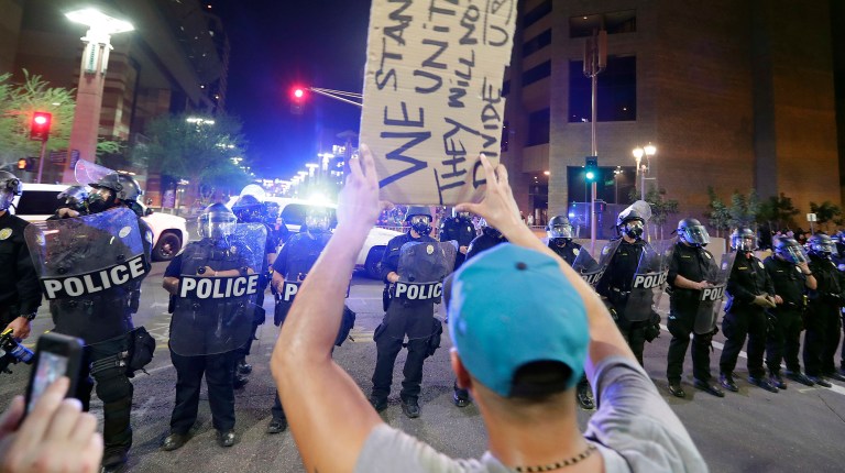 Amid the chaos police, wearing riot gear, fired canisters of tear gas or smoke, and flash bangs to disperse protesters as they began to dismantle barricades that were set up for the rally. (AP Photo/Matt York)