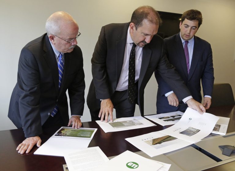 In this photo taken on Aug. 13, 2014, Kenneth Bouch, center, and Ben Kovler, right, of Green Thumb Industries, an Illinois-based partnership of medical marijuana entrepreneurs, review security plans for a proposed medical marijuana facility with security adviser Terry Gainer during a meeting in Chicago. Medical marijuana in Illinois will be encased in vaults, monitored by security guards and protected by fingerprint-recognition biometrics. That's the picture painted by business owners who are competing for a limited number of marijuana cultivation and dispensary permits under the state's new law. A detailed security plan will give an edge in the scoring, so many of the applicants say they're exceeding the Illinois law's already-strict requirements.(AP Photo/M. Spencer Green)