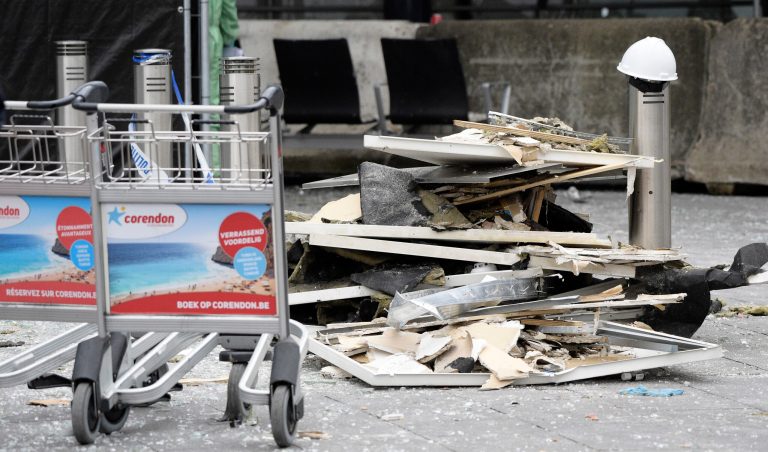 Luggage carts are parked near damage at Zaventem Airport in Brussels on Wednesday, March 23, 2016. Belgian authorities were searching Wednesday for a top suspect in the country's deadliest attacks in decades, as the European Union's capital awoke under guard and with limited public transport after scores were killed and injured in bombings on the Brussels airport and a subway station. (AP Photo/Yorick Jansens, Pool photo via AP)