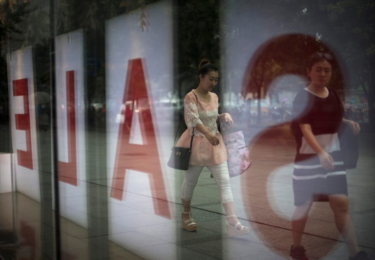 Women walk past a fashion outlet offering its summer sale at a shopping mall in Beijing, China Wednesday, July 16, 2014. China's economic growth edged up in the latest quarter and more than 7 million new jobs were created in the first half of the year, easing pressure on communist leaders as they try to prevent a precipitous slowdown in the world's second-largest economy. (AP Photo/Andy Wong)