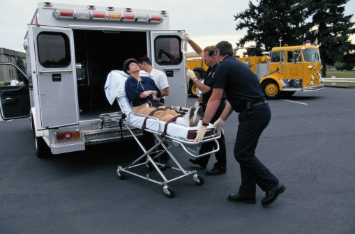 Wheeling Woman Into Ambulance