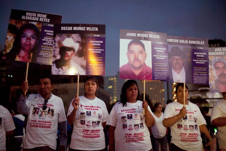   FILE - In this May 9, 2012 file photo, people hold photographs of their relatives who went missing during a protest that is part of the campaign 