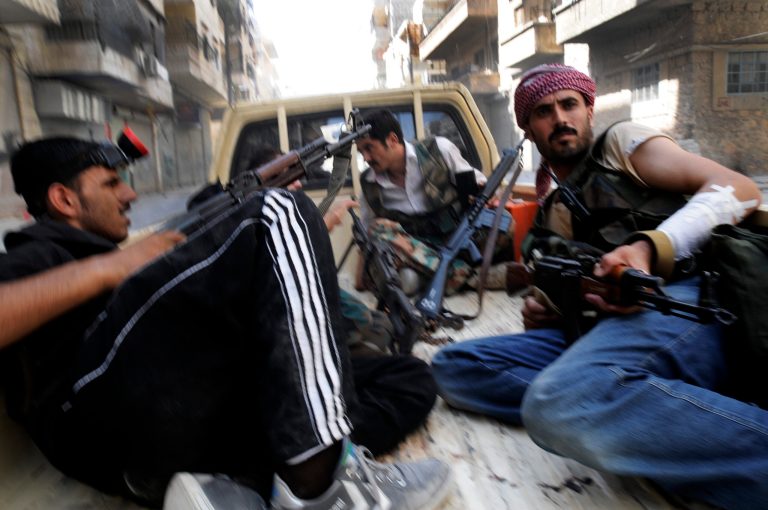 In this Wednesday, Aug. 1, 2012 photo, Free Syrian Army soldiers hold their weapons during clashes with government forces in at the south-west district of Salah al-Din in Aleppo, Syria. Syrian troops launched a ground assault Wednesday on the besieged northern city of Aleppo, but activists said rebels forces were fighting back in a battle for the country's largest city that has raged for more than two weeks. (AP Photo/Alberto Prieto)