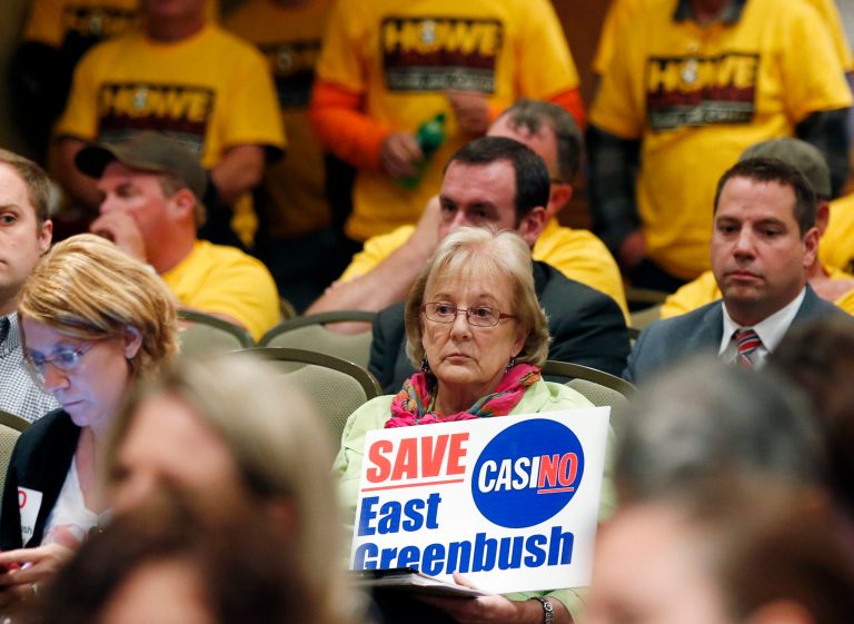 Marie Cookson of East Greenbush, N.Y., holds a sign opposing a casino in her town during a public meeting on casinos on Monday, Sept. 22, 2014, in Albany, N.Y. Supporters and critics of proposals for an Albany area casino are weighing in as three days of public hearings on casinos planned for upstate New York get underway. (AP Photo/Mike Groll)