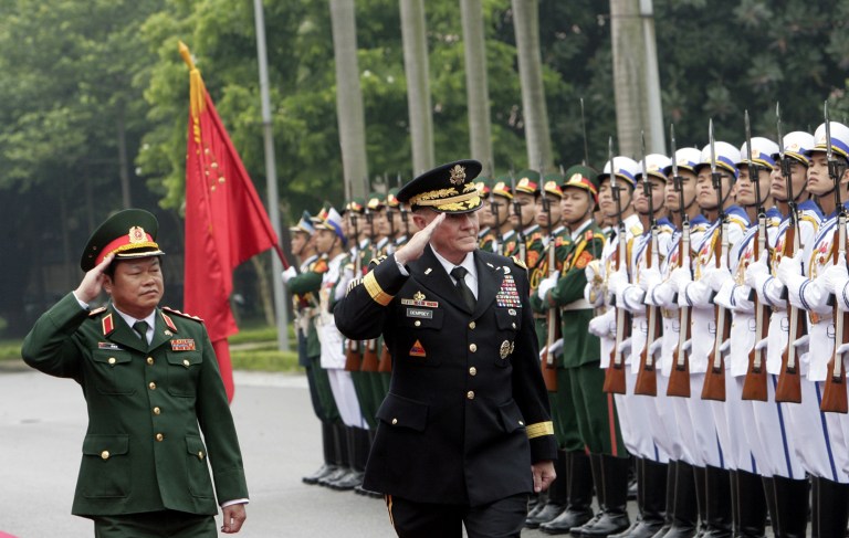 FILE - This Aug. 14, 2014 file photo shows U.S. Chairman of the Joint Chiefs of Staff, Gen. Martin Dempsey, right, and Vietnamese Chief of General Staff of the Army, Lt. Gen. Do Ba Ty, left, during an honor guard review before their talks in Hanoi, Vietnam. The easing of an arms embargo against Vietnam and a military agreement with the Philippines show the Obama administration wants deeper security ties with Asia. On Thursday, Oct. 2, 2014, the State Department announced it would allow sales, on a case-by-case basis, of lethal equipment to help the maritime security of Vietnam, easing a ban that has been in place since communists took power at the end of the Vietnam War in 1975. Hanoi welcomed the step, saying it would promote the U.S.-Vietnam partnership. (AP Photo/Tran Van Minh, File)