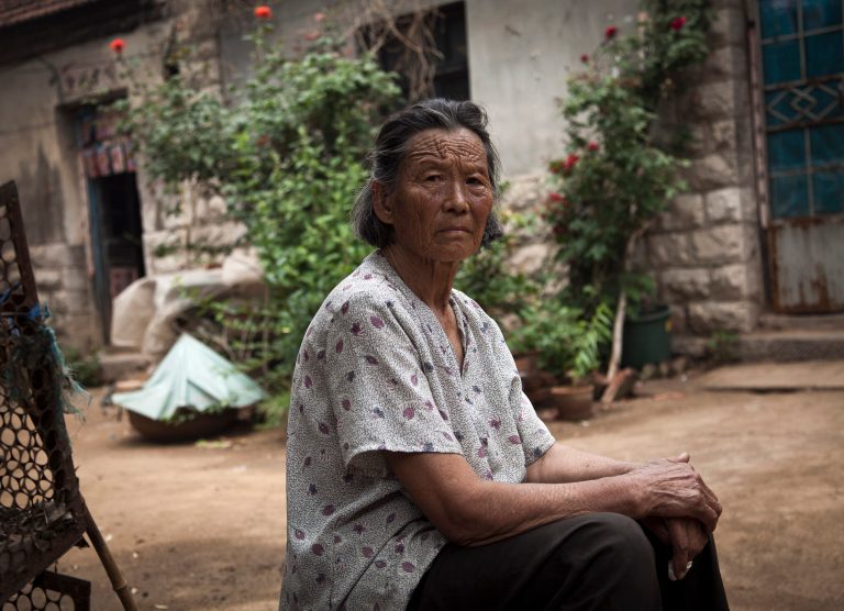   Wang Jinxiang, mother of Chen Guangcheng, takes a rest in the courtyard of her house where Chen was under house arrest, at the Dongshigu village, Shandong province, China, Friday, June 8, 2012. Cameras and security guards that kept Chen under house arrest have gone, but fear lingered among residents of his village Friday and even his mother advised him not to come home. (AP Photo/Andy Wong)  