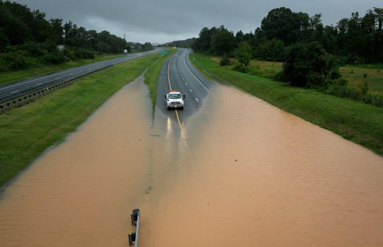 A truck sits at the edge of a flooded section of Interstate 695 in Baltimore, Tuesday, Aug. 12, 2014, after heavy rains fell across the Mid-Atlantic region. Officials shut down the Baltimore beltway in both directions at Quarantine Road due to heavy flooding. (AP Photo/Patrick Semansky)