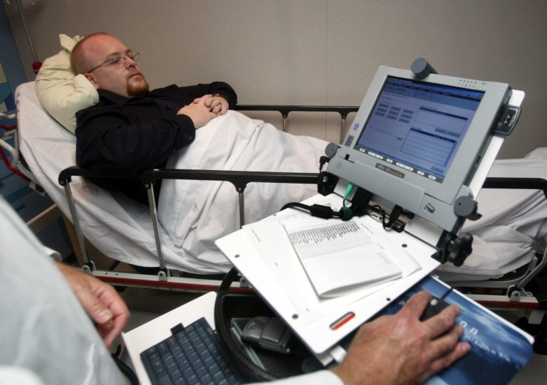 Jim Smith lies on a hospital bed during a demonstration of the wireless Carecast health information system June 11, 2003 in Hollywood, Florida. (Photo by Joe Raedle/Getty Images)