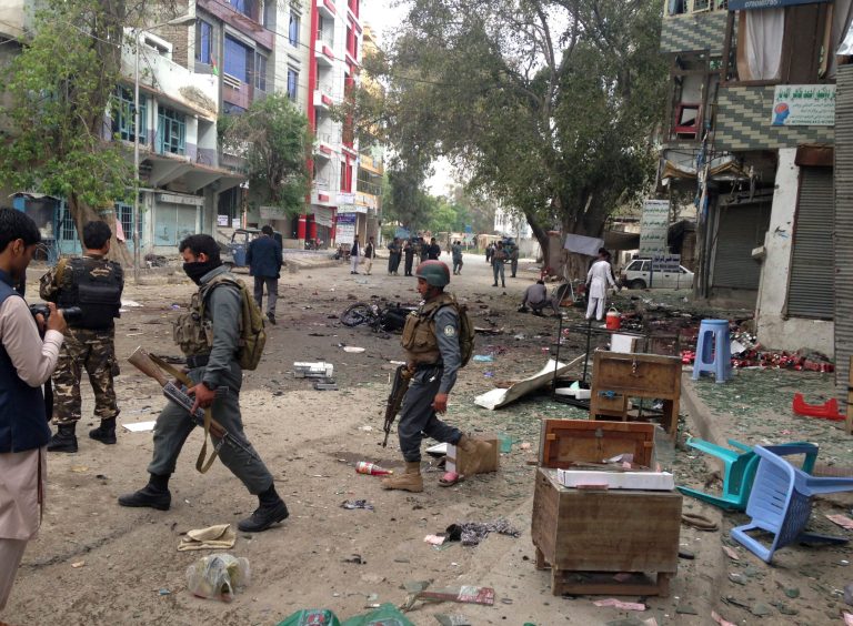 Afghan security forces members inspect the site of a suicide attack near a new Kabul Bank in Jalalabad, east of Kabul, Afghanistan, Saturday, April, 18, 2015. (AP Photo)