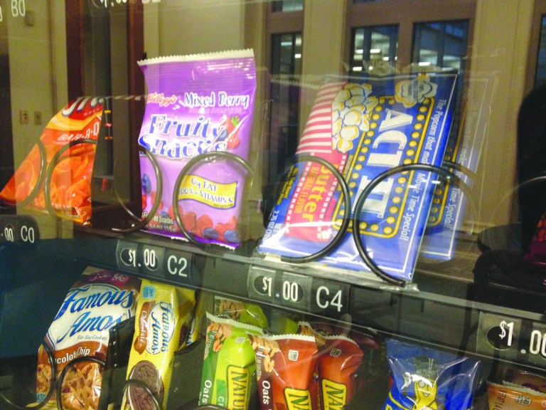 A vending machine in city hall Wednesday showed snack options that range from granola bars to chocolate chip cookies.