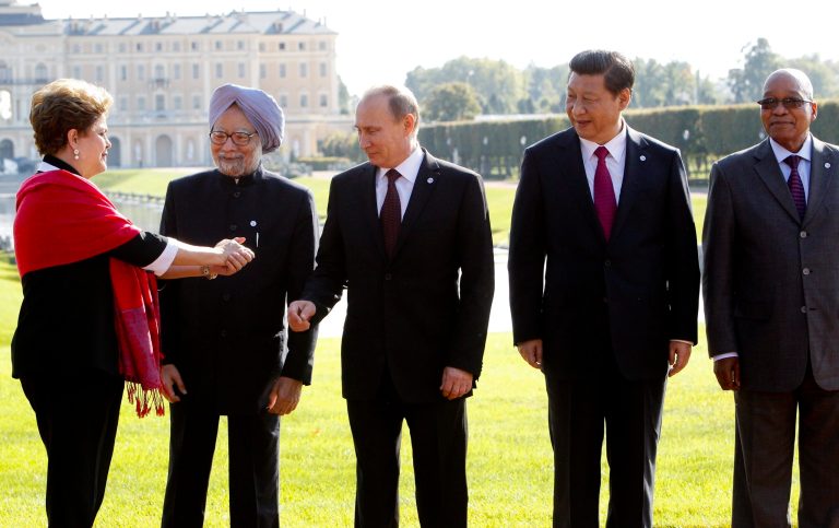 FILE - In this Sept. 5, 2013 file photo, from left, Brazil's President Dilma Rousseff gestures to then Indian Prime Minister Manmohan Singh, Russia's President Vladimir Putin, China's President Xi Jinping and South African President Jacob Zuma, as they gather for a group photo after a BRICS leaders' meeting at the G-20 Summit in St. Petersburg, Russia. In another sign of the shifting balance of power in the world economy, emerging market powers Brazil, Russia, India, China and South Africa are launching a $100 billion development bank to challenge the U.S.-dominated World Bank and help finance $4.5 trillion worth of infrastructure projects. (AP Photo/Sergei Karpukhin, Pool, File)