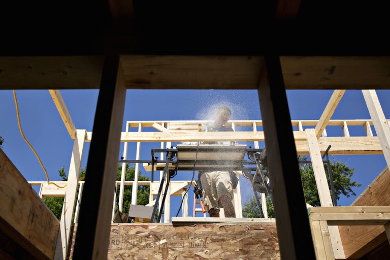 A contractor uses a saw to cut wood during construction of a new Doug Phillips Construction Inc. home in Walnut, Illinois, U.S., on Wednesday, Aug. 1, 2018. The U.S. Census Bureau is scheduled to release housing starts figures on August 16. 