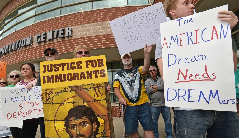 People at the Intermodal Center in Erie, Pa., protest President Donald Trump's decision to rescind former President Barack Obama's Deferred Action for Childhood Arrivals policy, which protects children of undocumented immigrants from being deported, Wednesday, Sept. 6, 2017. (Christopher Millette)/Erie Times-News via AP)
