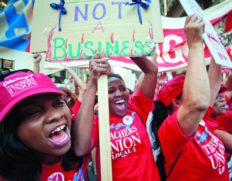 Public school teachers cheer as Chicago Teachers Union President Karen Lewis, unseen, arrives unexpectedly to address a rally of thousands of teachers gathered for the second consecutive day outside the Chicago Board of Education district headquarters in 2012 in Chicago. Teachers walked off the job for the first time in 25 years over issues including pay raises, classroom conditions, job security, and teacher evaluations. (AP Photo/Sitthixay Ditthavong)