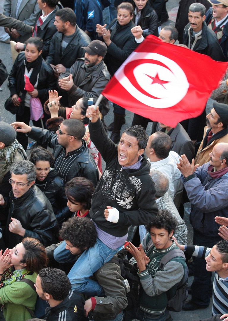   A member of the leftist UGTT union holds a Tunisian flag during a rally to commemorate the 1955 assassination of a historic member when they were attacked by the League for Protection of the Revolution, Tuesday, Dec. 4, 2012 in Tunis. League members are considered to be close to the Ennahda Party, which dominates Tunisiaâs post-revolution coalition government. (AP Photo/Amine Landoulsi)  