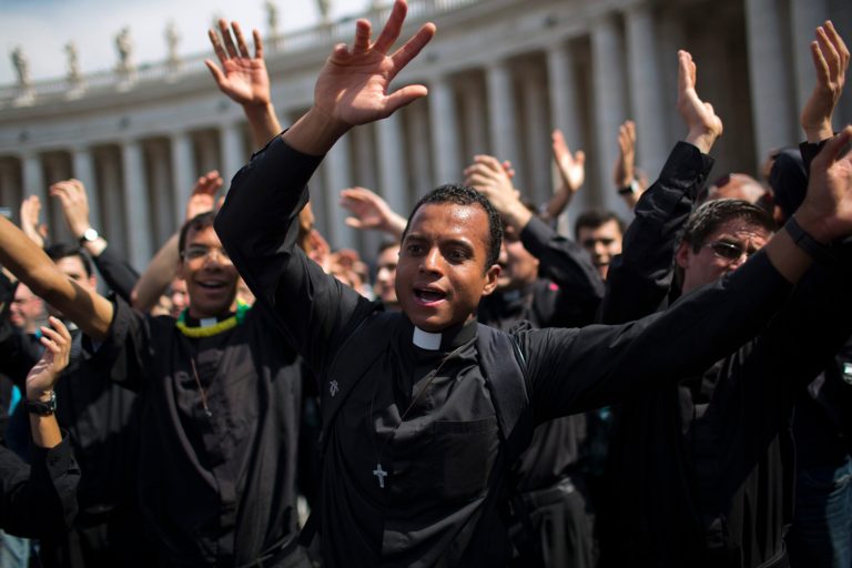 Priests sing and dance in St. Peter's Square at the Vatican, Saturday, April 26, 2014. Pilgrims and faithful are gathering in Rome to attend Sunday's ceremony at the Vatican where Pope Francis will elevate in a solemn ceremony John XXIII and John Paul II to sainthood. (AP Photo/Emilio Morenatti)