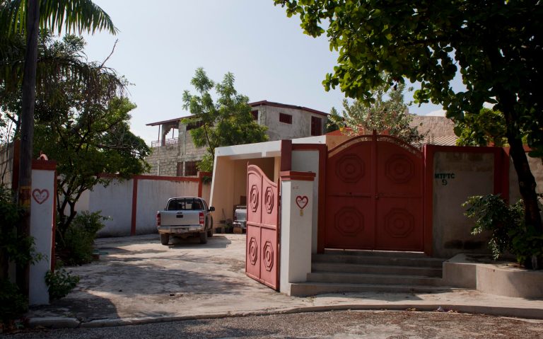 Pick-up trucks are parked at the entrance of  the home of George Knoop, 77,  an American missionary, where he was killed  this week, in Port-au-Prince, Haiti, Saturday, May 17, 2014.  Police say George Knoop, who worked as a volunteer for U.S.-based Missionary Flights International.  was fatally stabbed Tuesday afternoon in his home in the Delmas section of Haiti's capital. The 77-year-old missionary was apparently alone at the time and knew his assailant.( AP Photo/Dieu Nalio Chery)