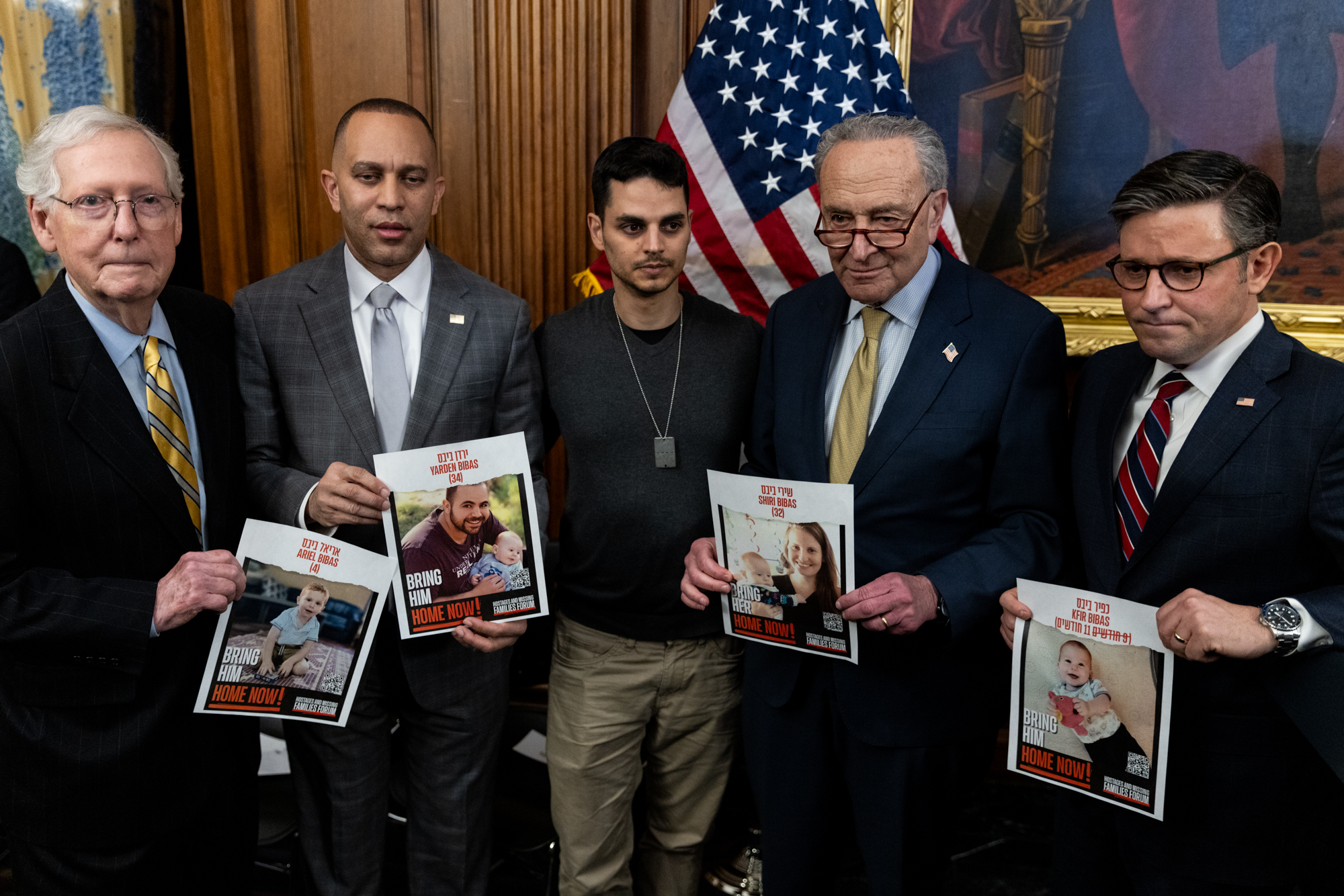 Senate Minority Leader Mitch McConnell (R-KY), House Minority Leader Hakeem Jeffries (D-NY), Tomer Keshet, whose cousin's family had been taken hostage during the Hamas attack on Israel, Senate Majority Leader Chuck Schumer (D-NY), and Speaker of the House Mike Johnson (R-LA) hold pictures of Israeli hostages after a menorah lighting in the Capitol on Dec. 12, 2023, to celebrate the eight-day festival of Hanukkah.