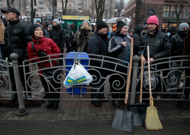 Demonstrators angered by more than two months of anti-government protests in Kiev gather on  Khreschatyk street in  Kiev, Ukraine,  Saturday, Feb. 8, 2014. Thousands of people angered by months of anti-government protests in the Ukrainian capital converged on one of the protesters' barricades Saturday, but retreated after meeting sizeable resistance. (AP Photo/Sergei Chuzavkov)