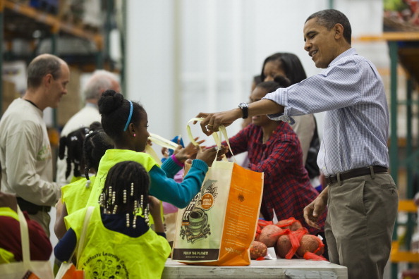 WASHINGTON, DC - NOVEMBER 21:  U.S. President Barack Obama hands out food to the needy for Thanksgiving at the Capitol Area Food Bank on November 21, 2012 in Washington, DC. President Obama also marked the Thanksgiving holiday today with the traditional Thanksgiving turkey pardon at the White House. (Photo by Jim Lo Scalzo-Pool/Getty Images)