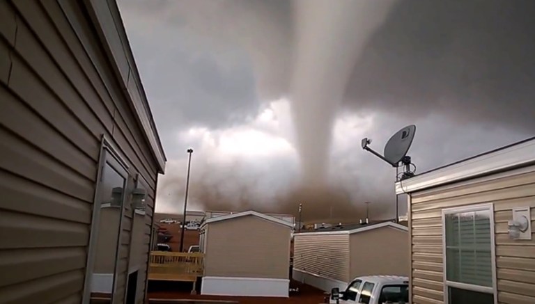 FILE - This Monday, May 26, 2014 file photo from video provided by Dan Yorgason, shows a tornado in a worker's camp near Watford City, N.D., in the heart of the state's booming oil patch. The tornado injured nine people, including a 15-year-old girl who suffered critical injuries, and damaged or destroyed more than a dozen trailers at the camp. When waves of workers began spilling into western North Dakota for high-paying oil jobs and nowhere to live, they set their eyes on the rural _ and unregulated _ prairie of McKenzie County. The population was booming so fast that no one knew how many people were in the county, so local officials pushed through ordinances that are now being credited in part with helping emergency workers during the severe storm that brought only the 14th tornado to the county in 65 years. (AP Photo/Dan Yorgason, File)