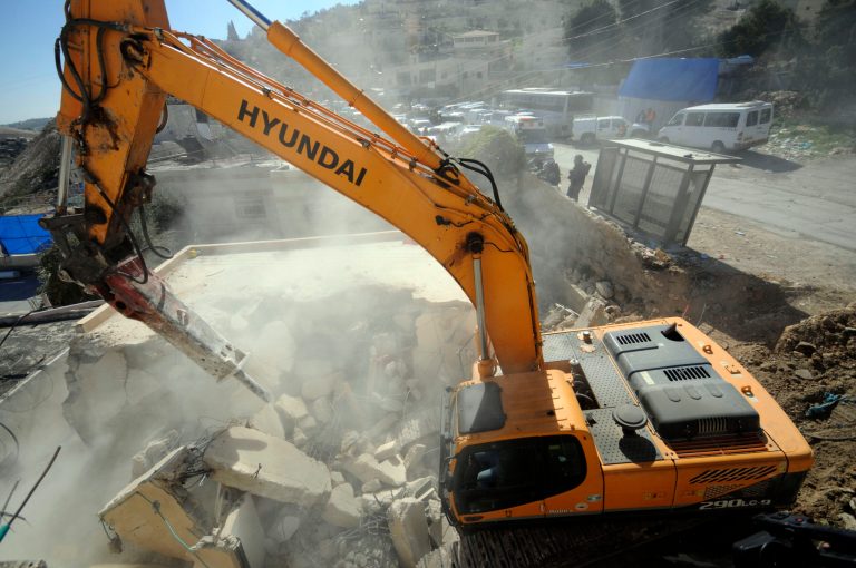 A bulldozer works on a Palestinian home demolished in East Jerusalem Wednesday, Feb. 5, 2014, Three Palestinian homes were demolished in the neighborhood, as the Israeli planners Wednesday gave final approval for 558 apartments in Jewish settlements in war-won east Jerusalem. (AP Photo/Mahmoud Illean)