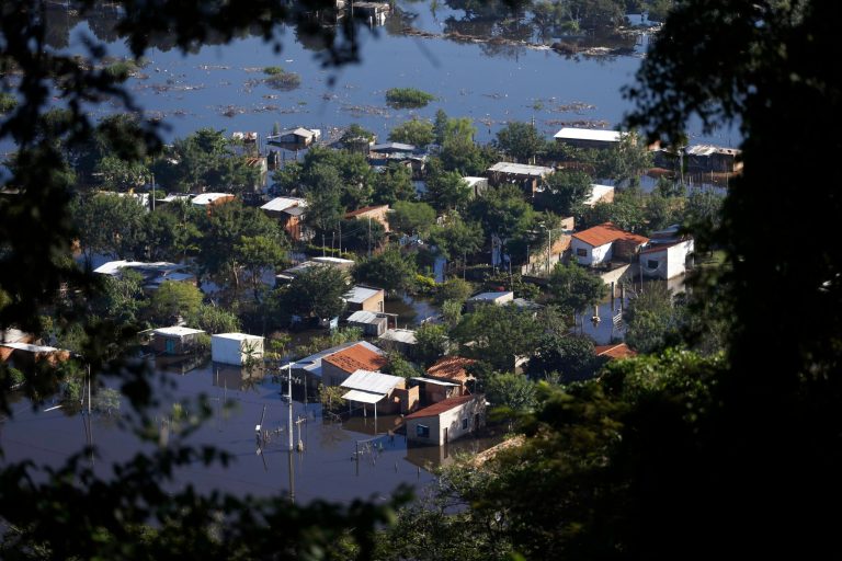 Homes are surrounded by floodwater in the Cateura neighborhood, seen from Lamabare Hill in Asuncion, Paraguay, Tuesday, June 10, 2014. Thousands of people living along the Paraguay River have been affected by flooding after the river overflowed its banks. (AP Photo/Jorge Saenz)