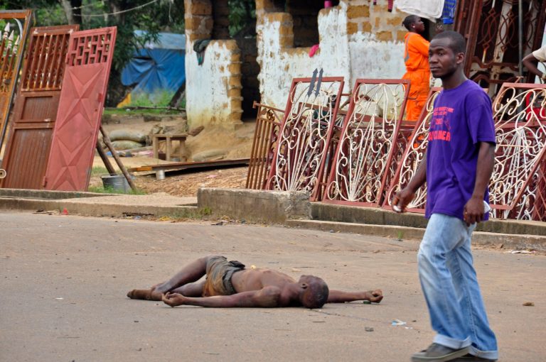 The lifeless body of a man lays unattended in the street as locals suspect him of dying from the deadly Ebola virus, as government warns the public not to leave Ebola victims in the streets in the city of Monrovia, Liberia, Tuesday,  Aug. 5, 2014.  A second American aid worker infected with Ebola arrived Tuesday in Atlanta, where doctors will closely monitor the effect of an experimental drug she agreed to take even though its safety was never tested on humans. Nancy Writebol arrived from Monrovia, Liberia, in a chartered plane at Dobbins Air Reserve Base and will join Dr. Kent Brantly in the isolation unit at Emory University Hospital, just downhill from the U.S. Centers for Disease Control and Prevention. (AP Photo/Abbas Dulleh)
