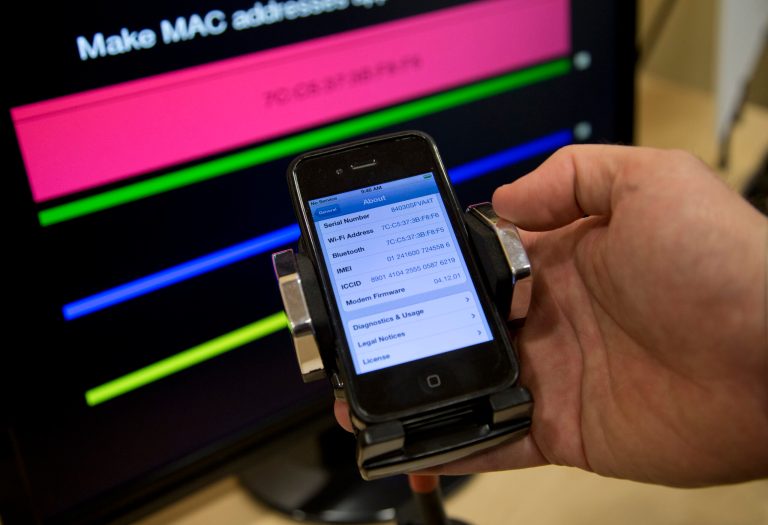 Technologist Seth Schoen holds a cell phone as it displays information, also seen on the screen behind, during a Federal Trade Commission (FTC) mobile tracking demonstration Wednesday in Washington. (AP Photo/Carolyn Kaster)
