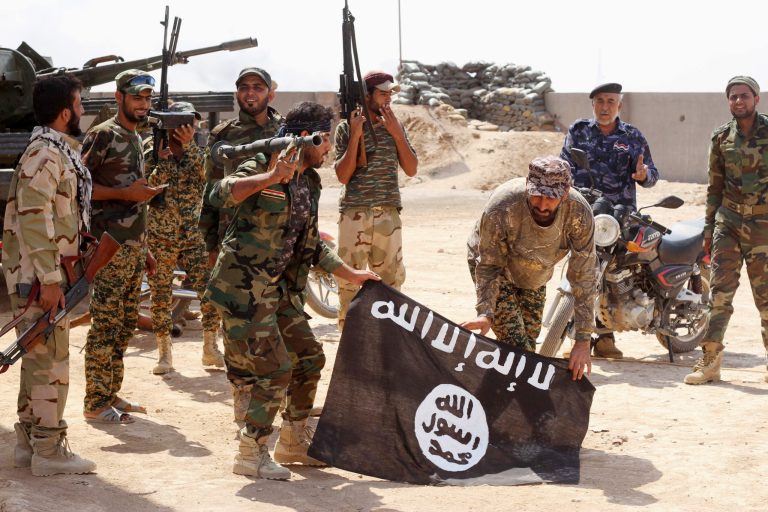 Iraqi security forces hold a flag of the Islamic State group they captured during an operation outside Amirli, some 105 miles (170 kilometers) north of Baghdad, Iraq. (AP Photo, File)