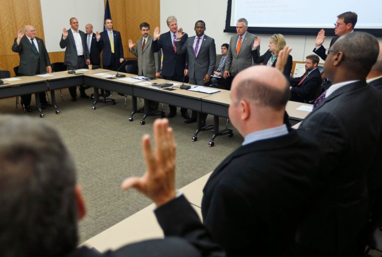 Members of the Governor's Commission on Climate Change are sworn in at the Capitol in Richmond, Va., Wednesday, Sept. 10, 2014 during the inaugeral meeting of the commission. The commission is chaired by McAuliffe Cabinet secretaries. Its membership totals more than 30. (AP Photo/Steve Helber)