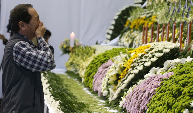 A mourner weeps as he pays tribute to the victims of the sunken ferry Sewol in the water off the southern coast at a gymnasium, in Ansan, South Korea, Wednesday, April 23, 2014. The victims are overwhelmingly students of a single high school in Ansan, near Seoul. More than three-quarters of the 323 students are dead or missing, while nearly two-thirds of the other 153 people on board the ferry Sewol when it sank one week ago survived. (AP Photo/Korea Pool)  KOREA OUT