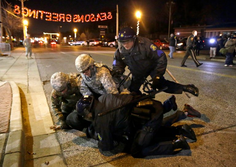 A protester is taken into custody Friday in Ferguson, Mo. (AP/Jeff Roberson)