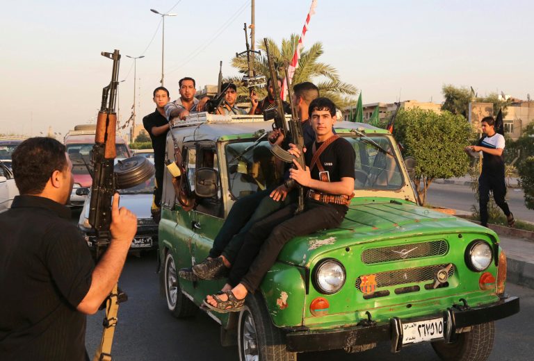 Iraqi Shiite tribal fighters deploy with their weapons while chanting slogans against the al Qaeda-inspired Islamic State of Iraq and the Levant (ISIL), to help the military, which defends the capital in Baghdad's Sadr City, Iraq, Friday. (AP Photo/ Karim Kadim)