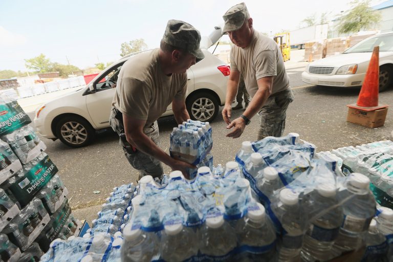 NEW ORLEANS, LA - SEPTEMBER 03: Louisiana Air National Guard soldiers distribute supplies to residents at a Point of Distribution center on September 3, 2012 in New Orleans, Louisiana.  Around 240,000 residents remain without power in Louisiana following Hurricane Isaac.  (Photo by Mario Tama/Getty Images)