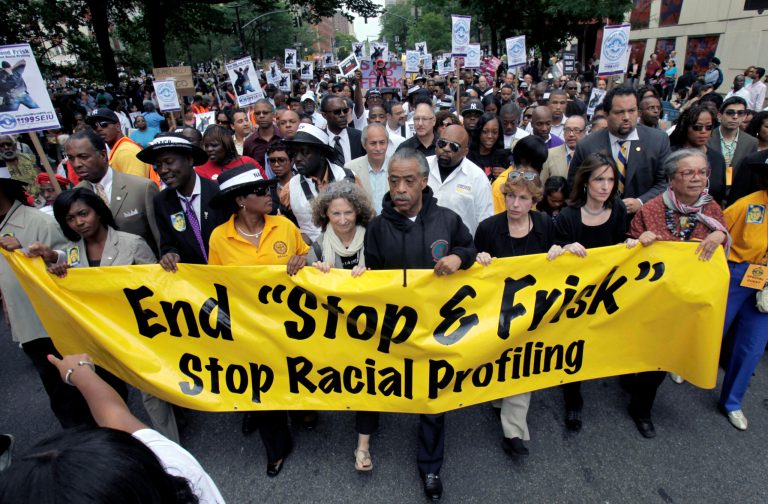   The Rev. Al Sharpton, center, walks with demonstrators during a silent march to end the 