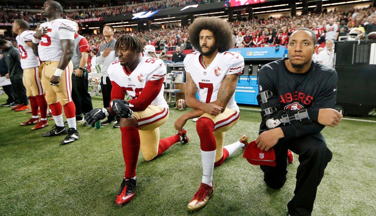 San Francisco 49ers quarterback Colin Kaepernick and outside linebacker Eli Harold kneel during the playing of the national anthem before an NFL football game. President Trump said he would love to see owners of NFL teams fire any player that disrespects the American flag. (AP Photo/John Bazemore, File)
