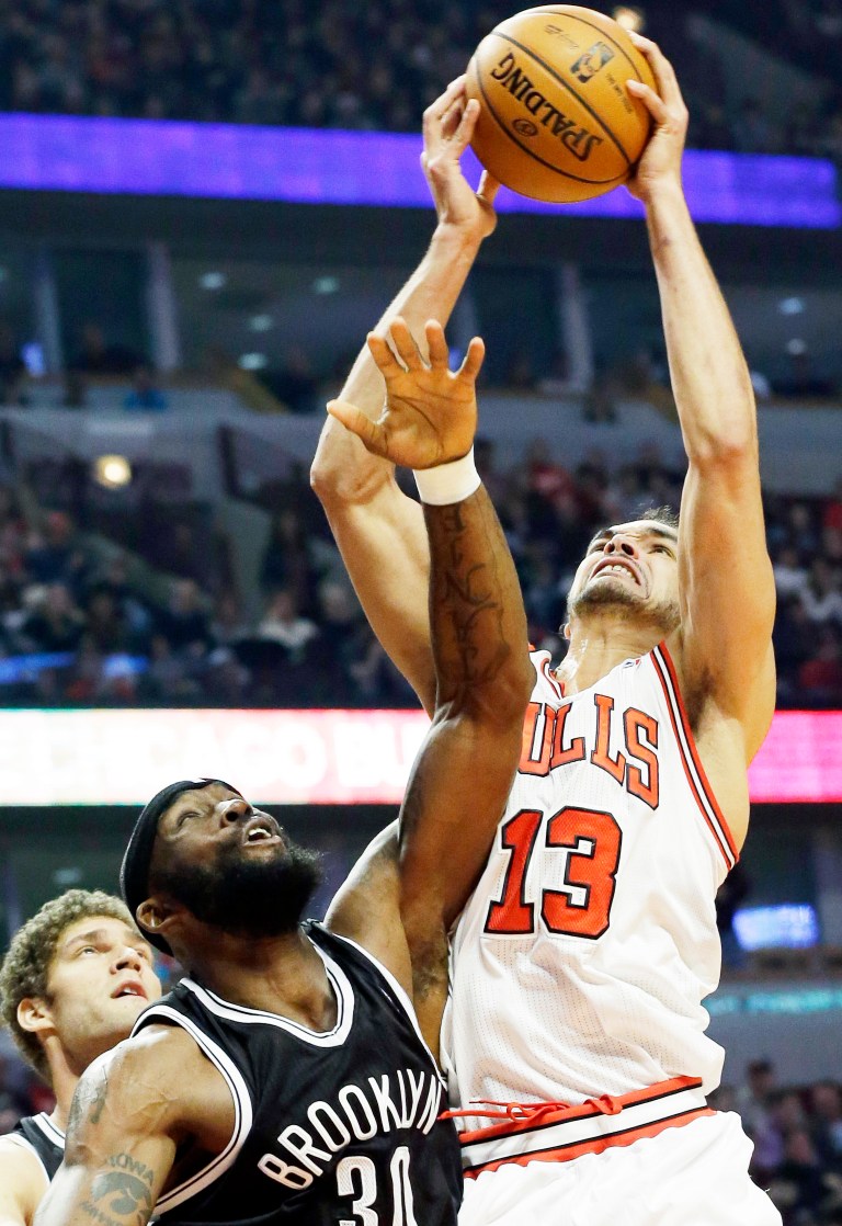   Chicago Bulls center Joakim Noah, right, gets a rebound as Brooklyn Nets center Brook Lopez, left, and forward Reggie Evans look on during the first half of an NBA basketball game in Chicago on Saturday, Dec. 15, 2012. (AP Photo/Nam Y. Huh)  