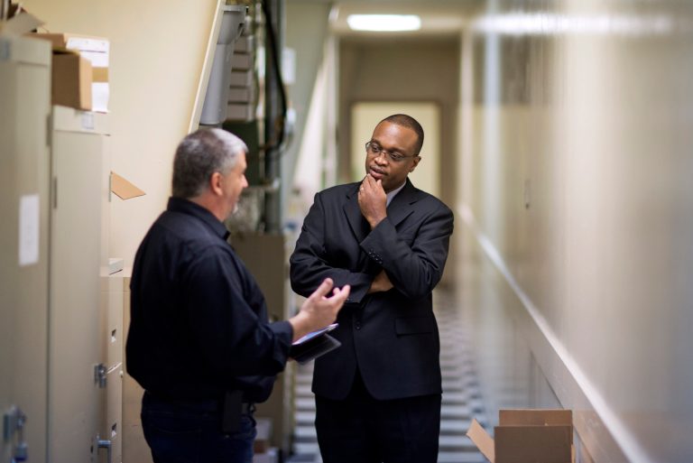 FILE - In this Thursday, Nov. 14, 2013, file photo, retired U.S. Navy Chief Jerome Porter, right, of Atlanta, talks with Joe Corsino, executive director of Welcome Home Resumes, after conducting an audio recording in a quiet hallway for Porter's interactive resume during a job fair for veterans at the VFW Post 2681, in Marietta, Ga. The government reports on state unemployment rates for October on Friday, Nov. 22, 2013. (AP Photo/David Goldman, File)