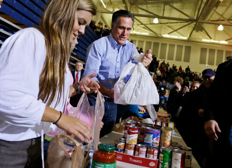 Republican presidential candidate Mitt Romney holds bags of food as he participates in a campaign event collecting supplies from residents local relief organizations for victims of superstorm Sandy in Kettering, Ohio. (AP Photo)