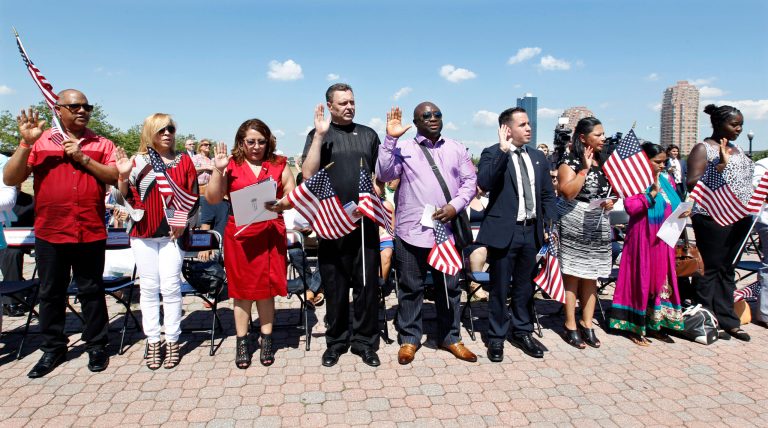 A group of people take the oath of allegiance during their naturalization ceremony at Liberty State Park on July 4 in Jersey City, N.J. (AP Photo/Mel Evans)
